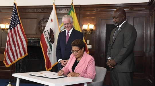 Council President Krekorian and Councilmember Harris-Dawson watch as Mayor Bass signs their ordinance reforming zoning code. 