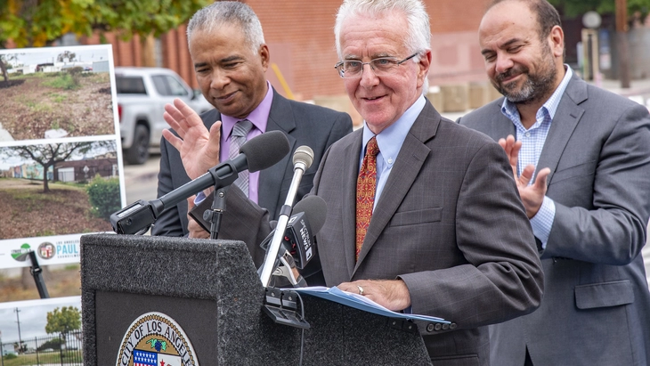 Council President Krekorian speaks at lectern as Streets LA Chief Keith Mozee and former State Assemblymember Adrin Nazarian listen and applaud. 