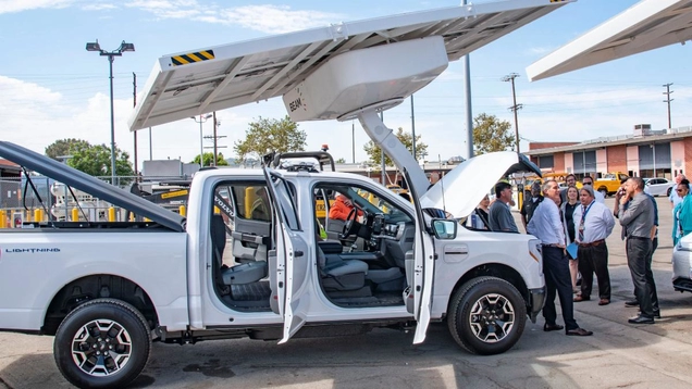 Electric pickup truck being charged at solar charging station