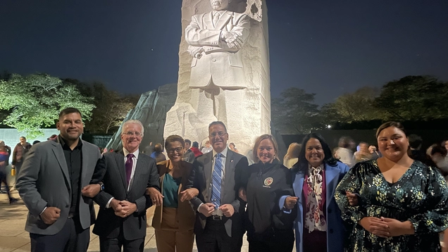 Councilmembers and Mayor Bass lock arms under monumental statue of Dr. Martin Luther King, Jr.